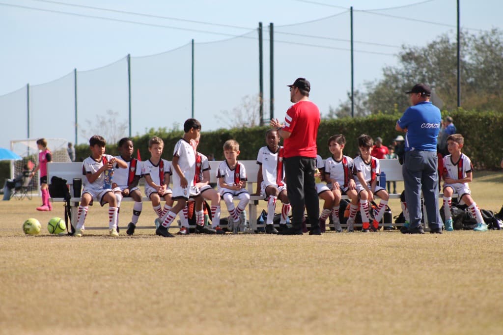 A Dr. Phillips Soccer Club coach talking to the team on the bench